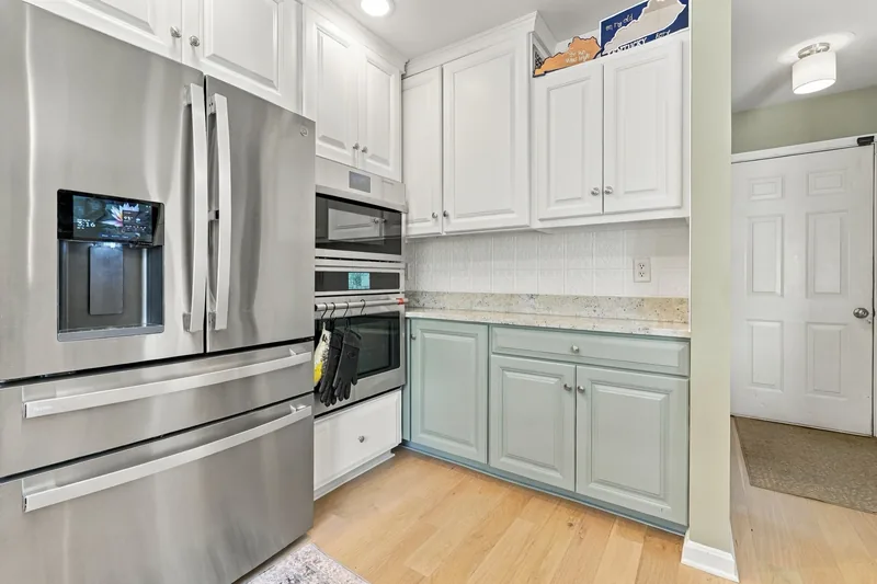 Kitchen with white and sage cabinets and stainless appliances