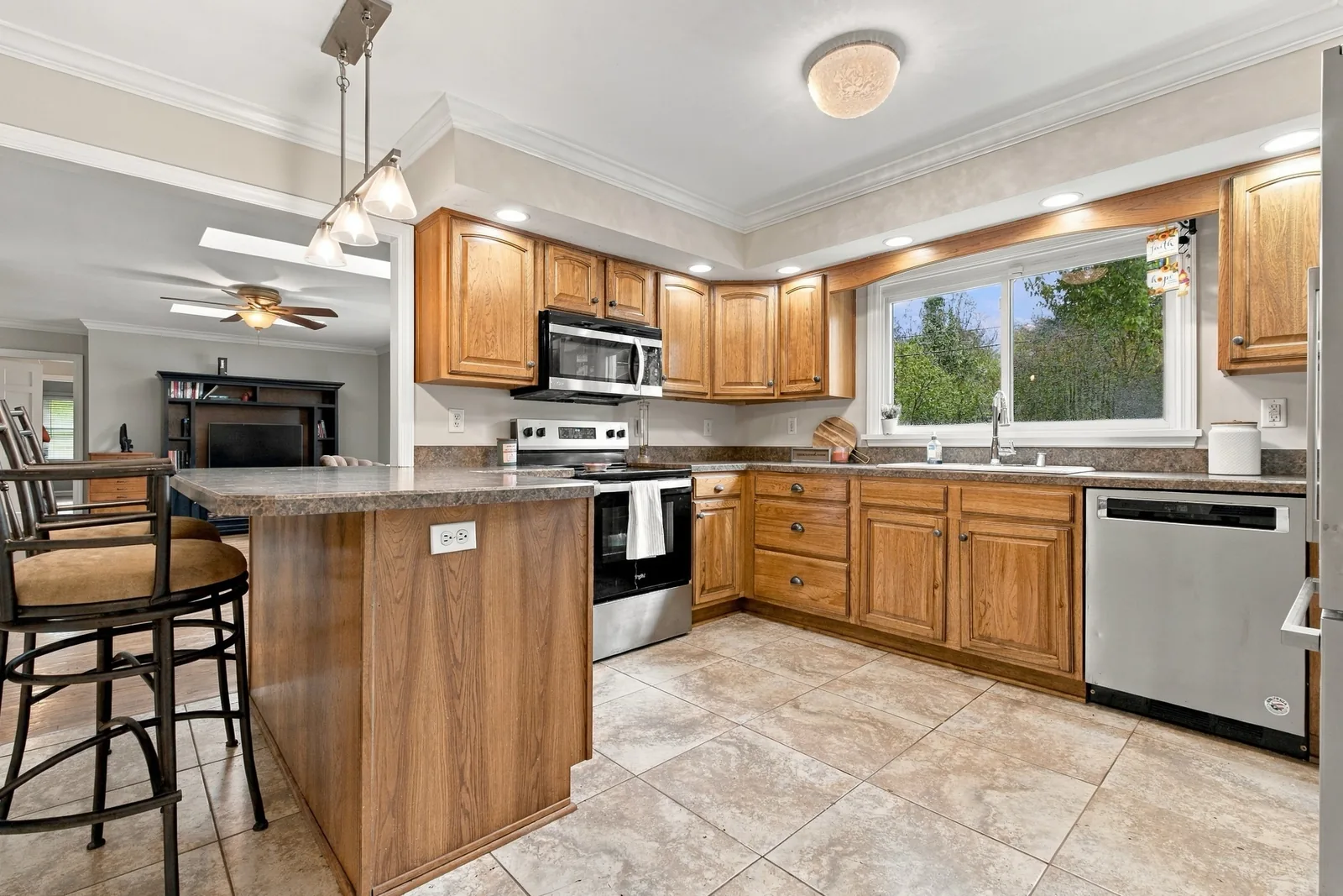 The kitchen and its breakfast peninsula, open to the family room