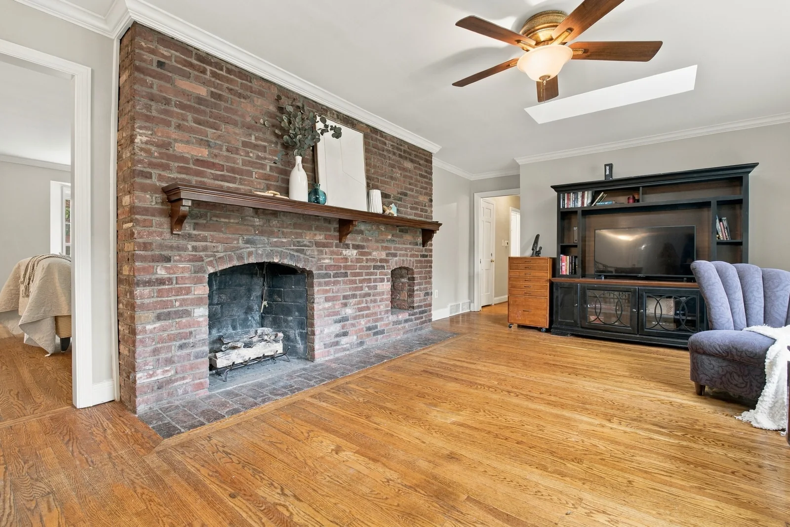 The family room brick wall fireplace with a wood mantel