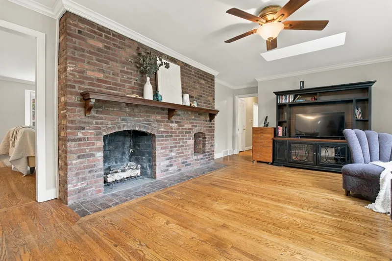 Family room brick wall fireplace with a wood mantel